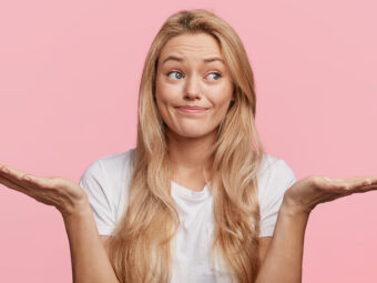 Puzzled hesitant female with long blonde hair dressed casually, shrugs shoulders as doesn`t know answer or can`t make decision, being clueless and uncertain. Life perception and attitude concept